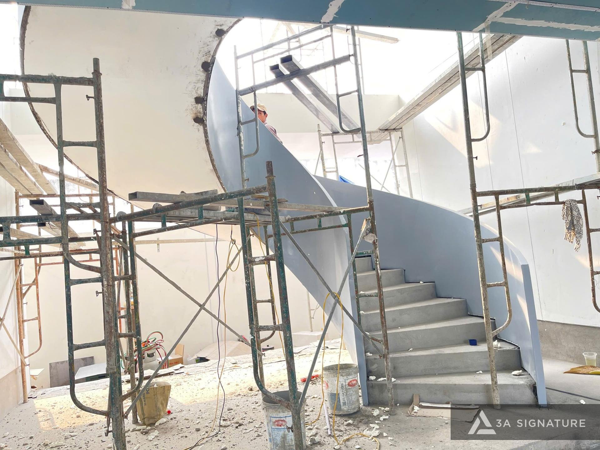 Thi công Diamond Villa Tây Ninh – cầu thang xoắn bê tông liền khối uốn cong tinh tế, điểm nhấn nghệ thuật kết nối các tầng trong không gian Tropical Modern.