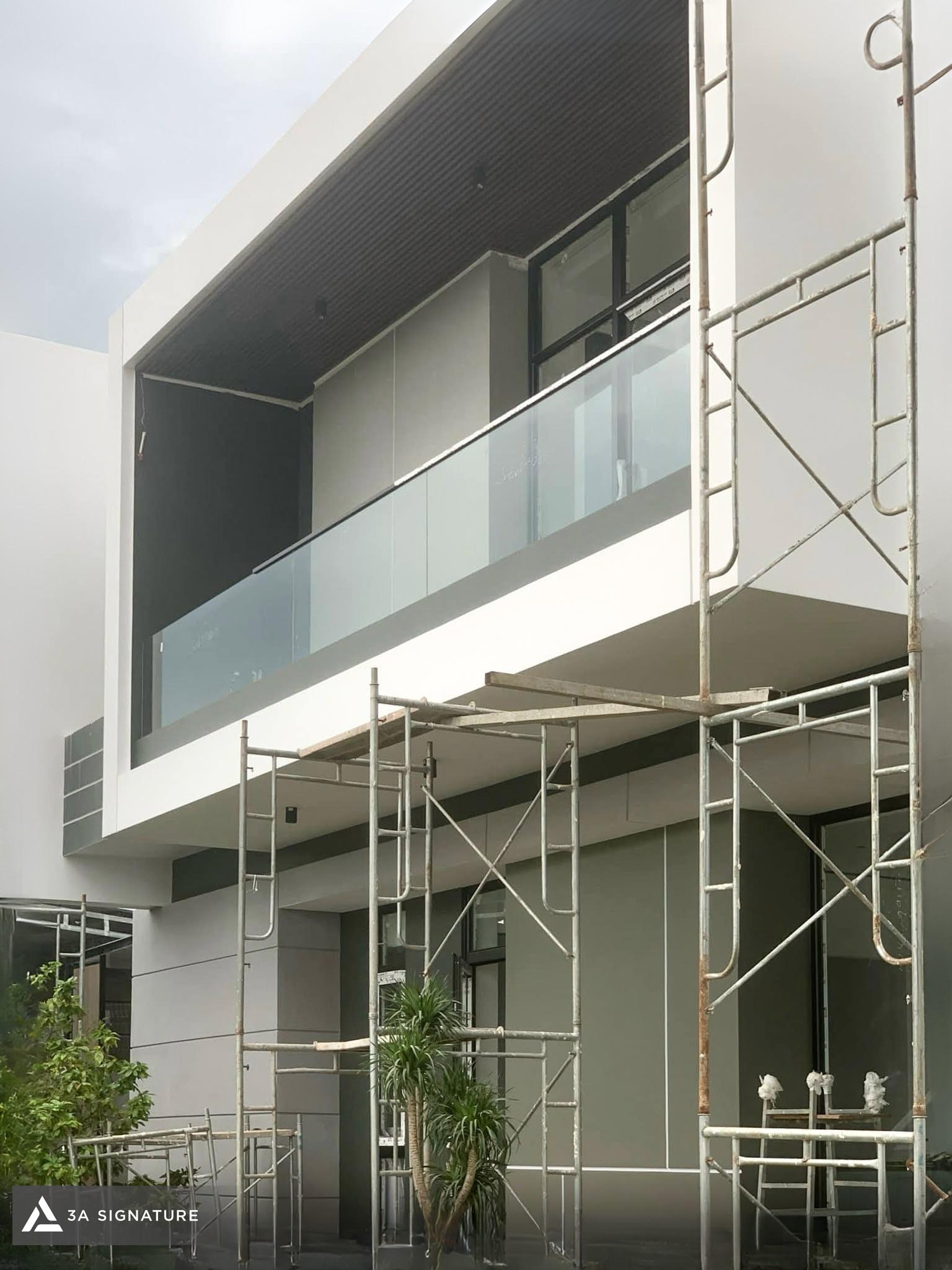 Hoàn thiện biệt thự Modern Tropical với hệ vách kính, cửa lùa kịch trần và khung nhôm lớn giúp định hình mặt đứng mở, sáng và hiện đại.