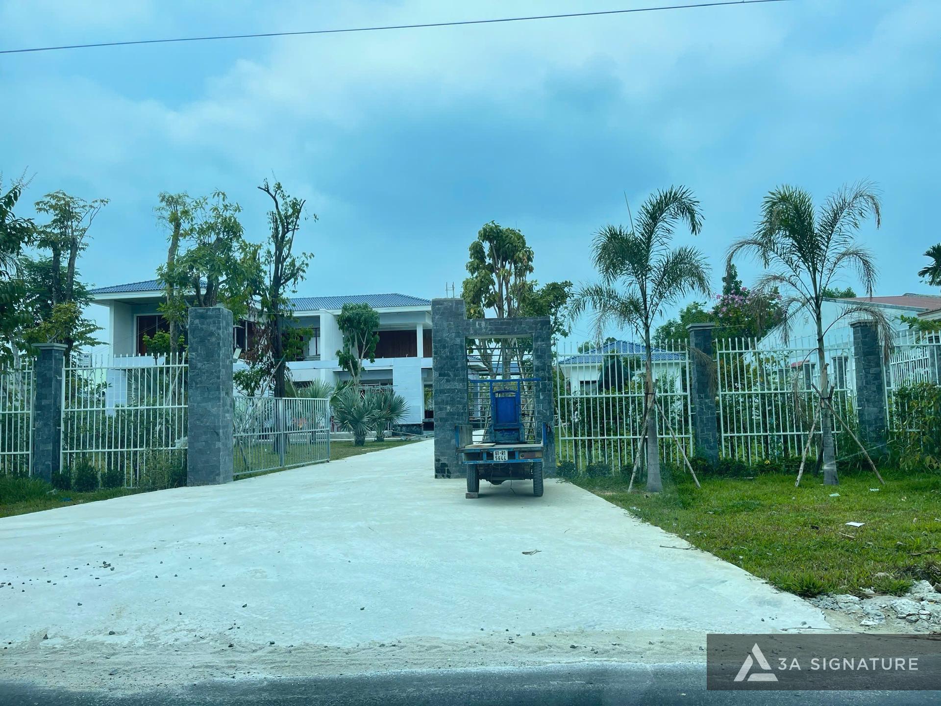 Tiến Độ Thi Công P Villa - Bước Gần Hơn Đến Không Gian Sống Hoàn Mỹ Hình ảnh P Villa do 3A Signature thực hiện, với cổng đá, hàng cây và thảm cỏ xanh bao quanh, thể hiện triết lý thiết kế Tropical hiện đại và bền vững.